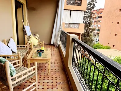 a balcony with chairs and a table on a balcony at perle studio familial in Marrakech