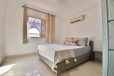 a bedroom with a bed and a window at Appartement Les Huit Palmiers in Marrakech
