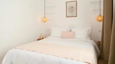 a bedroom with a white bed with a pink pillow at Riad Reflet D'orient Marrakech in Marrakech