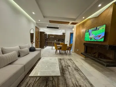 a living room with a couch and a tv on a wall at Luxury Retreat 2Bdr Appartment In Prime Marrakech in Marrakech