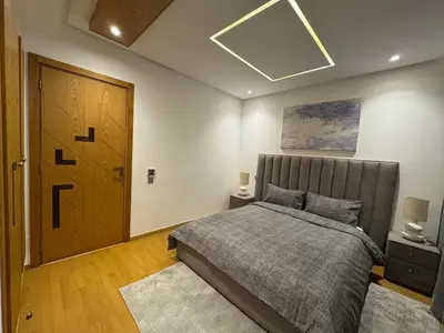 a bedroom with a bed and a wooden door at Luxury Retreat 2Bdr Appartment In Prime Marrakech in Marrakech