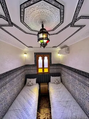 two beds in a room with a ceiling at Apartment with rooftop access in Marrakech