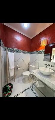 a bathroom with two sinks and a toilet in it at Rouge Mamounia in Marrakech