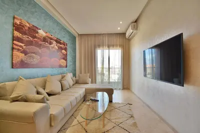 a living room with a couch and a flat screen tv at Central location-Queensize bed- Parking, AC & Iptv in Marrakech