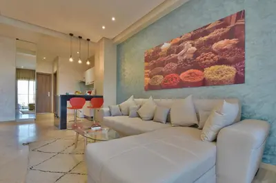a living room with a white couch and a painting at Central location-Queensize bed- Parking, AC & Iptv in Marrakech