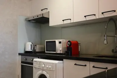 a kitchen with a washing machine and a microwave at Central location-Queensize bed- Parking, AC & Iptv in Marrakech