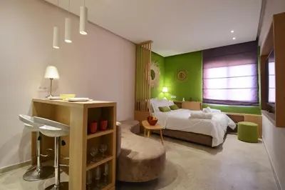 a bedroom with green walls and a bed and a chair at 1BR Studio-AC & IpTV-Downtown Gueliz-perfect for 2 in Marrakech