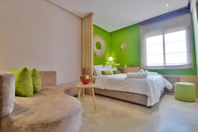 a bedroom with green walls and a bed and a couch at 1BR Studio-AC & IpTV-Downtown Gueliz-perfect for 2 in Marrakech