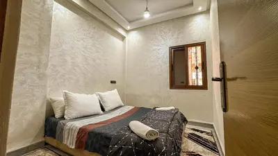 a small room with a bed and a door at Apartment near the airport in Marrakech