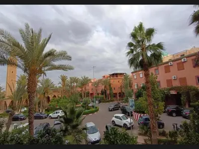 a view of a parking lot with palm trees and buildings at Riyad jennah in Marrakech