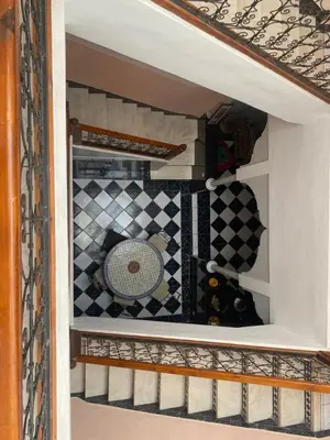 a room with a checkered floor and a table at Riyad jennah in Marrakech