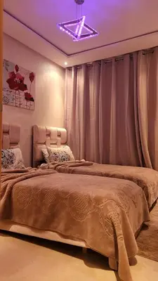 two beds in a bedroom with a purple ceiling at Achraf in Marrakech