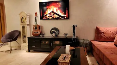 a living room with a couch and a guitar on the wall at Achraf in Marrakech