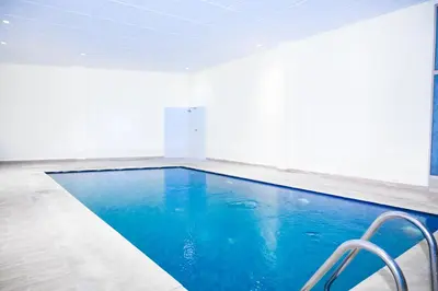 a swimming pool in a room with blue water at Luxury Odyssey Private Pool in Marrakech