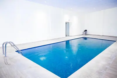 a swimming pool in a white room with blue water at Luxury Odyssey Private Pool in Marrakech