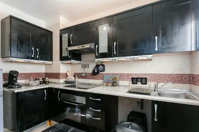 a kitchen with black cabinets and a sink at Atlas Golf Resort - piscine - rooftop in Marrakech