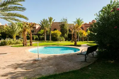 a small swimming pool in a park with a chair at Atlas Golf Resort - piscine - rooftop in Marrakech