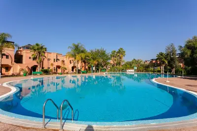 a large swimming pool with blue water at Atlas Golf Resort - piscine - rooftop in Marrakech