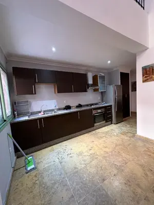 a kitchen with brown cabinets and a mop at Duplexe Mirador Majorelle in Marrakech