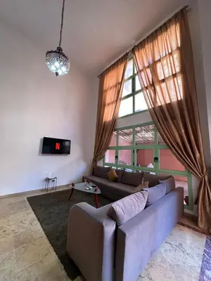 a living room with a couch and a large window at Duplexe Mirador Majorelle in Marrakech