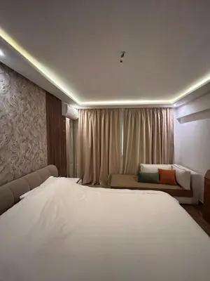 a bedroom with a large white bed and a couch at Appartement avec piscine Marrakech in Marrakech