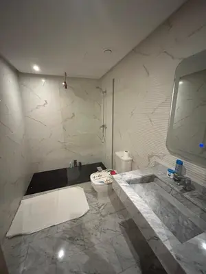 a white bathroom with a sink and a toilet at Appartement avec piscine Marrakech in Marrakech