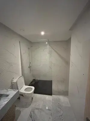 a white bathroom with a toilet and a shower at Appartement avec piscine Marrakech in Marrakech