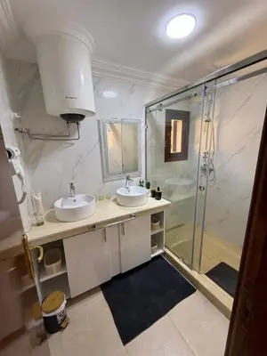 a bathroom with two sinks and a shower at Appartement La Palmeraie Marrakech in Marrakech