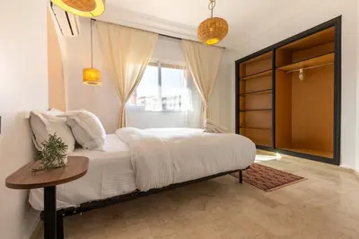 a bedroom with a bed with a table and a window at Modern & Chic Apartment in Gueliz, Marrakech in Marrakech