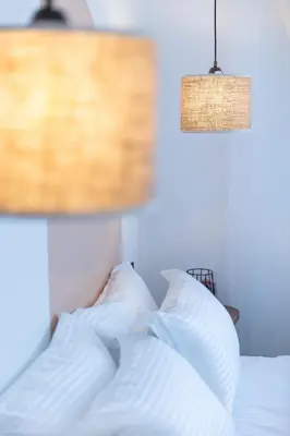 a bed with white pillows and a lamp at Modern & Chic Apartment in Gueliz, Marrakech in Marrakech