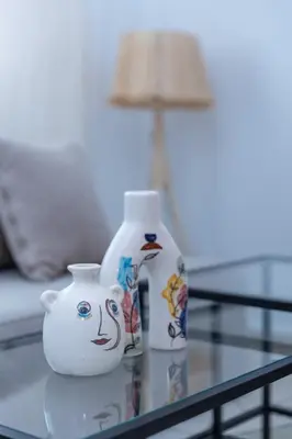 a glass table with a vase and a bottle on it at Modern & Chic Apartment in Gueliz, Marrakech in Marrakech