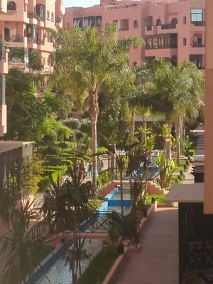 a view of a resort with a pool and palm trees at Palmeraie Gates in Marrakech