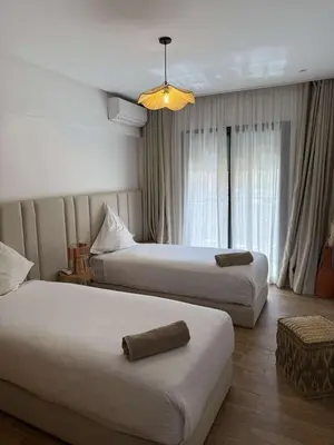 a hotel room with two beds and a window at Palmeraie Gates in Marrakech