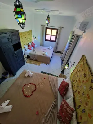 a living room with a bed and a living room with a room at Dar ESSEKIA in Marrakech