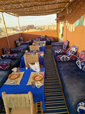a group of tables in a room with blue tables and chairs at Dar ESSEKIA in Marrakech