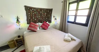 a bedroom with a bed with red pillows and a window at Dar ESSEKIA in Marrakech