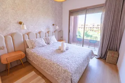 a bedroom with a large bed and a large window at Marrakech confort et détente à Argan Golf prestigia in Marrakech