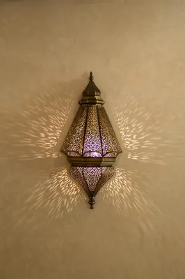 a light fixture hanging on a wall with shadows at PL Place Boutique Hôtel & Restaurant in Marrakech