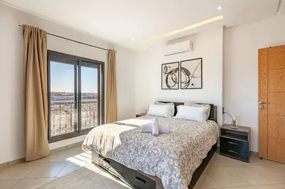 a bedroom with a bed and a large window at Super apartment in marrrakech in Marrakech