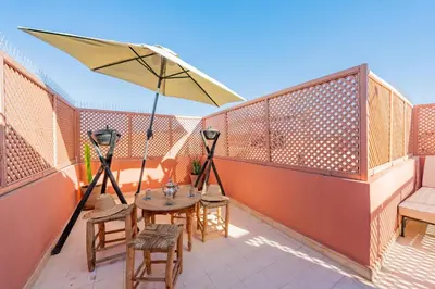 a patio with a table and chairs and an umbrella at Dar KADO, Charming Hideaway in the Heart of Marrakech Medina in Marrakech