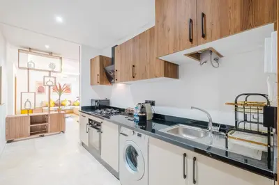 a kitchen with a sink and a dishwasher at 3 min de Guéliz - Appart avec balcon , vue piscine in Marrakech