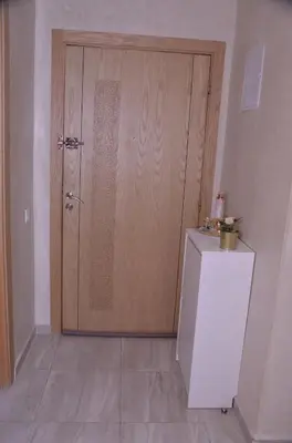 a large wooden door in a room with a refrigerator at Appartement moderne in Marrakech