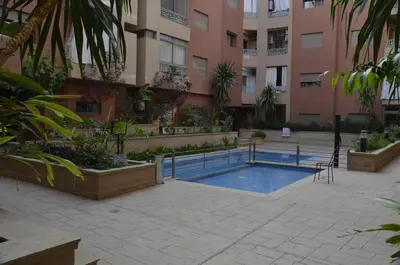 a swimming pool in front of a building at Appartement moderne in Marrakech