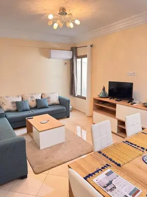 a living room with a couch and a tv at Appartement sur Marrakech in Marrakech