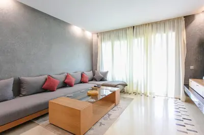 a living room with a couch and a coffee table at Bel appartement vue sur piscine, fibre optique, parking gratuit in Marrakech