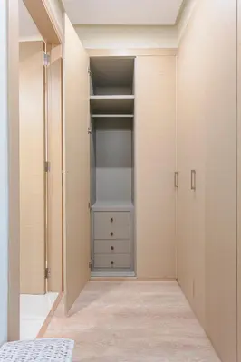 a walk in closet with white walls and white cabinets at Bel appartement vue sur piscine, fibre optique, parking gratuit in Marrakech