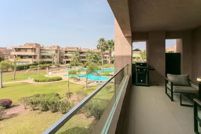 a balcony with a view of a resort at Bel appartement vue sur piscine, fibre optique, parking gratuit in Marrakech