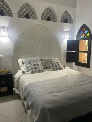 a bedroom with a large bed with a headboard at Riad zouina in Marrakech