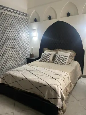 a bedroom with a large bed with a black headboard at Riad zouina in Marrakech