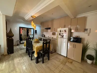 a kitchen with a table with chairs and a refrigerator at Central Fiber Optic Pool in Marrakech